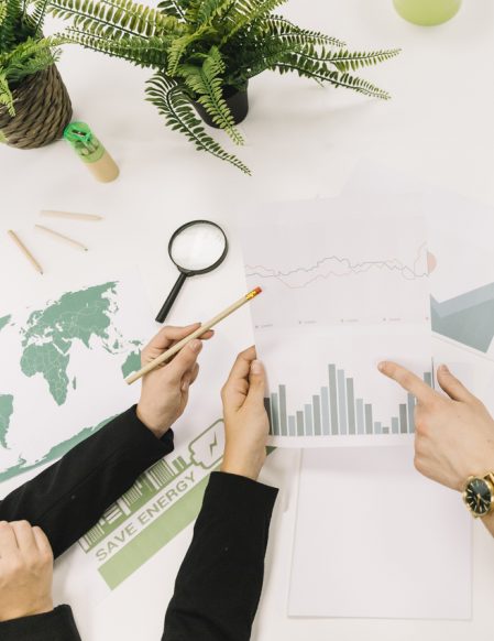 elevated-view-of-businesspeople-analyzing-graph-over-desk