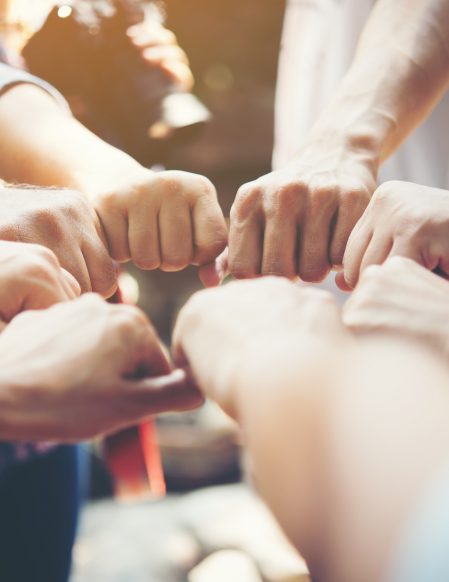 Close up of young people putting their hands together. Team with stack of hands showing unity and teamwork.